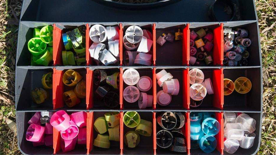 Spray can caps in an organised container
